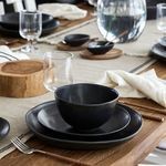 Plate shown stacked with a matching matte black bowl and plate on a wooden dining table