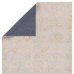 Back side of rug with dark gray backing visible at folded corner