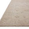 Close-up angled view showing the low pile and detailed border of the oatmeal and stone rug