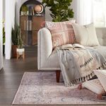 Side view of living room setup with Kadin Medallion rug under sofa with pink patterned pillows and throw