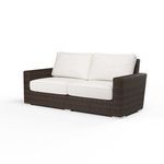 Angled front view showcasing plush cushions and detailed wicker armrests