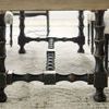 Side view of Ciao Bella table base showing black turned legs and stretcher with distressed finish