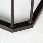 Close-up on metal frame corner showing welds and dark finish on iron base