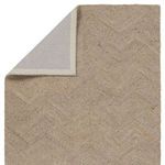Close crop of rug’s chevron pattern emphasizing alternating tan and gray linear loops