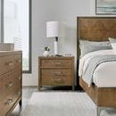 Nightstand styled in a bedroom next to a bed with a lamp and decorative objects on top