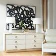 Ansel cabinet styled in a bright room with hardwood floor, white chair, lamps, and abstract black artwork