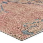 Close-up angle showing woven texture and color transitions of pink and blue on rug surface