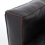 Close-up of corner armrest showing top-grain leather texture and distinct brown contrast stitching