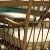 Close-up of curved cane armrest and cushion fabric on outdoor arm chair by poolside