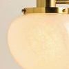 Close-up of frosted Cloud Glass bud with textured surface and aged brass mounting detail