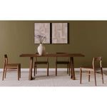 Four walnut chairs with dining table styled in dining room setting with green wall and carpet