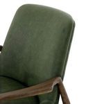Leather backrest close-up showing subtle grain detail and oak armrest pivot
