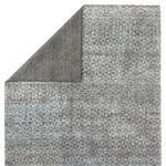 Back of rug visible with folded corner showing tightly woven backing in dark gray