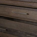Close-up of partially opened top drawer with metal handle highlighting wood texture and joinery