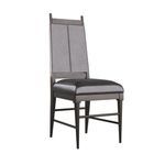 Side angle view showing sleek tapered legs and crossbars of the black leather dining chair