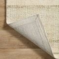 Corner of rug flipped over revealing sturdy woven backing on wood flooring