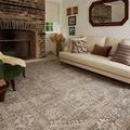 Ida Taupe / Multi Rug styled in living room setting with beige sofa and brick fireplace