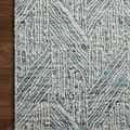 Corner of rug on wooden floor showing tight weave, handwoven texture, and detailed geometric pattern