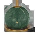 Close-up on green marble globe base with brass power button and black cord