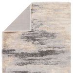 Back corner of rug folded to reveal underside with flat weave backing in cream tone