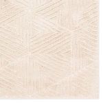 Close crop of geometric rug’s cream triangle pattern highlighting pile variation and texture