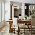 Francis rug under dining table with cream upholstered chairs in a bright dining area
