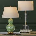 Deville Table Lamp positioned on gold and black console table between decorative books and flower arrangements