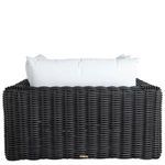 Back view of woven rattan chair with tall white back cushions