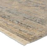 Close-up on fringed edge showing texture and distressed trellis design in blue and beige tones