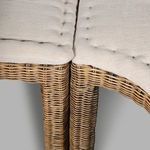 Close-up of side armrest corner with tightly woven rattan and cushioned seating edges