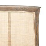 Close-up of upper cane backrest framed by curved oak wood with distinct wood grain.