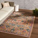 rug styled in a modern indoor setting beneath a wicker sofa and side table on dark wood flooring