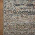 Close-up of the rug's corner showing detailed vintage motifs and border against a wooden floor