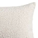 Close-up of top corner showing plush, textured off-white pillow fabric