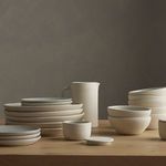 Salt jar featured among coordinated cream ceramic kitchenware in lifestyle table setting