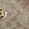 rug styled on floor with decorative bowl, book, and green sprig on top