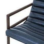 Close view of chair seat cushion with smooth upholstery and wooden armrest frame