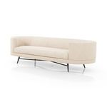 Ivory taupe upholstered sofa with soft pillowing, curved arms, black stainless steel splayed legs and cross-base stretchers