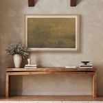 Painting shown in warm room setting framed by wooden ceiling beams and styled with books and vase.