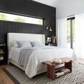 Kenzie rug styled under bed in modern bedroom with black accent wall and natural light
