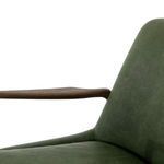 Oak armrest detail against green leather showing smooth finish and ergonomic contour