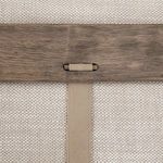 Back close-up showing repeating leather strap detail connecting wood panel on sofa