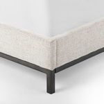 Close-up of bottom corner showing linen fabric on frame and gunmetal iron leg detail