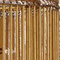 Close-up on distressed gold leaf finish and metal rings attaching long tentacles to upper circular frame