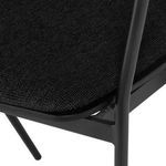 Close-up of the textured polyester fabric seat cushion and the smooth matte black metal frame corner