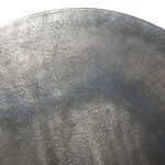 Macro view of round tabletop surface showing patina and natural irregularities in metal finish