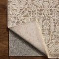 Rug corner lifted to show underside texture and backing on hardwood floor