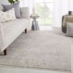 Lourdes Trellis rug styled in a bright living room with light-colored sofa, side table, and cushions