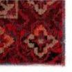 Close-up of rug corner showing detailed red and black medallion elements and fabric texture