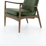 Low angled close-up of chair leg with oak wood grain and textured leather cushion